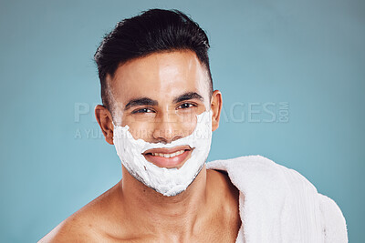 Buy stock photo Face, beauty and shaving with a man model in studio on a blue background for wellness or grooming. Portrait, skincare and hair removal with a handsome young male in the bathroom to shave his beard