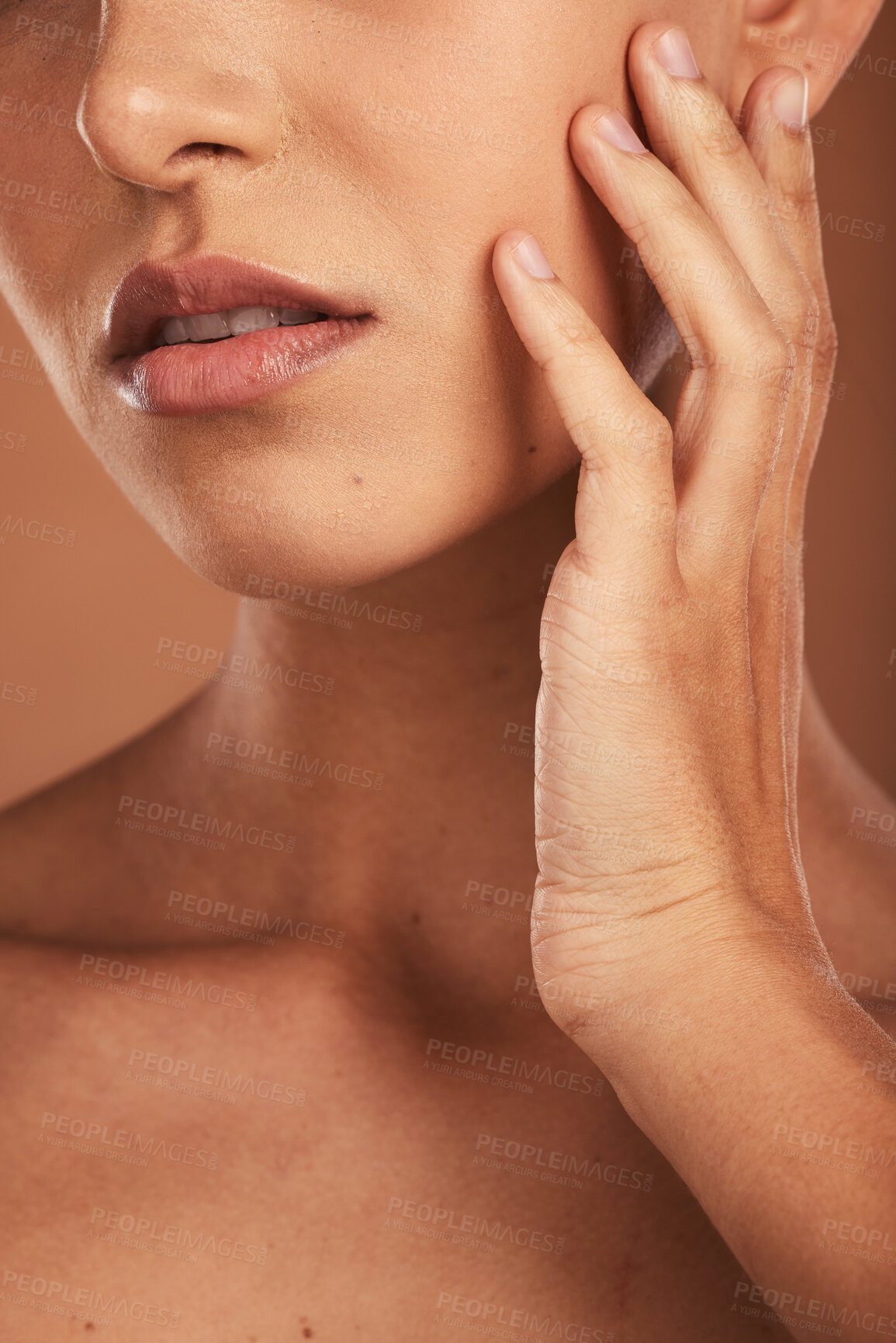 Buy stock photo Hand, face and skincare with a closeup woman touching her skin in studio on a beige background for wellness or treatment. Cosmetics, luxury and beauty with a female inside to promote natural care