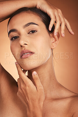 Buy stock photo Portrait, skincare and beauty with a model woman touching her face in studio on a beige background. Hands, wellness and luxury with a female posing to promote a natural product or skin treatment
