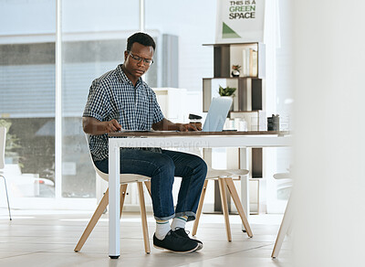 Buy stock photo Black man, startup business and employee with laptop working in an open office for creative design, digital marketing and advertising company. Modern workplace, strategy thinking and planning at desk