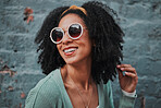Black woman, fashion and smile with stylish glasses for summer travel against an urban wall background. Happy African American female smiling in satisfaction for fun funky style in the outdoors