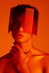 Orange, futuristic and man with a neon visor for cyberpunk, creative style and art against a studio background. Digital, fashion and face portrait of a model with a designer product for future 