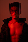Cool, cyberpunk and man with glasses for futuristic style, fashion and creative digital design in a neon room with studio background. Aesthetic art, dark and model with red lighting for creativity