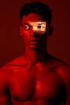 Neon red, dark light and black man with artistic lighting design, beauty and creative facial shadow. Luxury skincare glow, aesthetic creativity and health wellness model isolated on studio background
