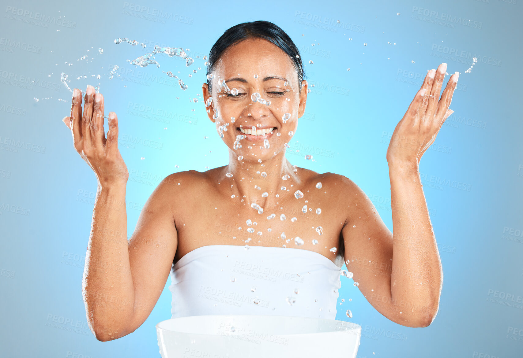 Buy stock photo Water splash, skincare and beauty of a woman with a smile with healthy and skin wellness. Happy hygiene treatment and morning facial routine of a female model face with happiness about grooming