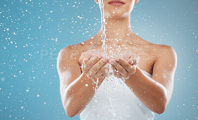 Buy stock photo Hands, splash and water for hygiene or grooming on a blue studio background. Skincare, wellness and health with a female cleaning, cleansing or washing her hands while isolated on a backdrop 