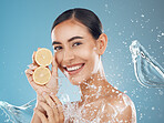 Lemon skincare, woman and water splash for vitamin c, natural cosmetics and healthy beauty product on studio blue background. Happy model face, nutrition fruit and self care dermatology for wellness 