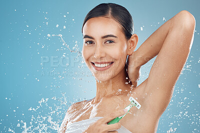 Buy stock photo Studio, portrait and woman shaving armpit with a razor blade for hair removal, hygiene and body wellness. Smile, blue background and happy young girl shaves underarms for healthy clean skincare 