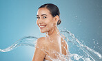 Beauty woman with water splash and skincare, clean and fresh skin, with body wellness, hydration and health portrait. Model, smile and washing, cosmetics with natural makeup with studio background.