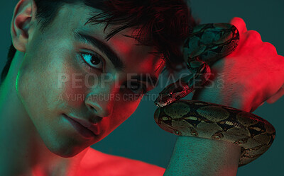 Buy stock photo Beauty, fashion and portrait of man with snake in neon studio shoot with danger and creative art style. Skincare, color and lights, healthy male model with seductive and sexy look on green background