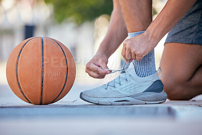 Buy stock photo Basketball, sports and shoes with a man athlete tying his laces before a game on an outdoor court. Fitness, exercise and sport with a male basketball player fastening his shoelaces for a match