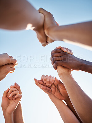Buy stock photo Low angle, group and holding hands in support, trust huddle and motivation for global success, volunteer community or diversity. People, friends or teamwork collaboration in circle for climate change