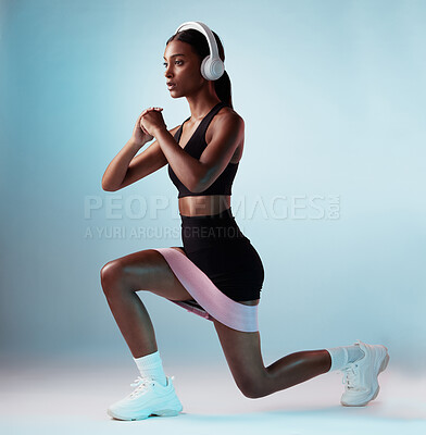 Buy stock photo Woman, music headphones or resistance band workout on blue background in studio for training, exercise or gym. Personal trainer, person or fitness model with health goals, radio or motivation podcast