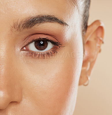 Buy stock photo Eye, vision and beauty with a model woman closeup in studio on a beige background for eyecare or skincare. Zoom, cosmetics and wellness with a female posing to show her eyelash, eyebrow or pupil