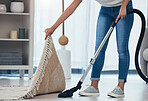 Woman, cleaning and doing house work with vacuum machine appliance for living room carpet to clean dirt or dust. Feet of female cleaner or housewife doing housekeeping on lounge floor for hygiene
