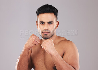 Buy stock photo Fist, boxing and young man on studio background doing training for health, fitness and wellness with workout. Indian male, fight position and dedicated for match, motivation and energy for practice.