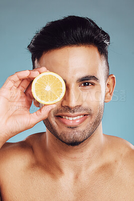 Buy stock photo Skincare, lemon and man in studio for beauty, wellness and cleaning, detox and diet on blue background mockup. Face, fruit and portrait of mexican model happy, smile and relax with vitamin C product