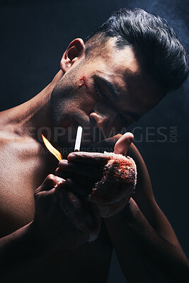 Buy stock photo Boxer, man and cigarette smoking after fight, blood and bandage from injury against a black studio background. Fighter smoke after boxing, training or mma match with bruise, violence and blood scar