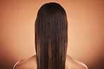 Brunette woman, shine and hair care, beauty salon, balayage and hair dye, color cosmetics and wig extension on studio orange background. Back of head, scalp and long hair style with smooth texture 