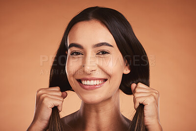 Buy stock photo Portrait of woman holding hair for beauty, hairstyle and fashion isolated on orange background in studio. Beauty salon, smile and face of young female with healthy skin, wellness and hair products