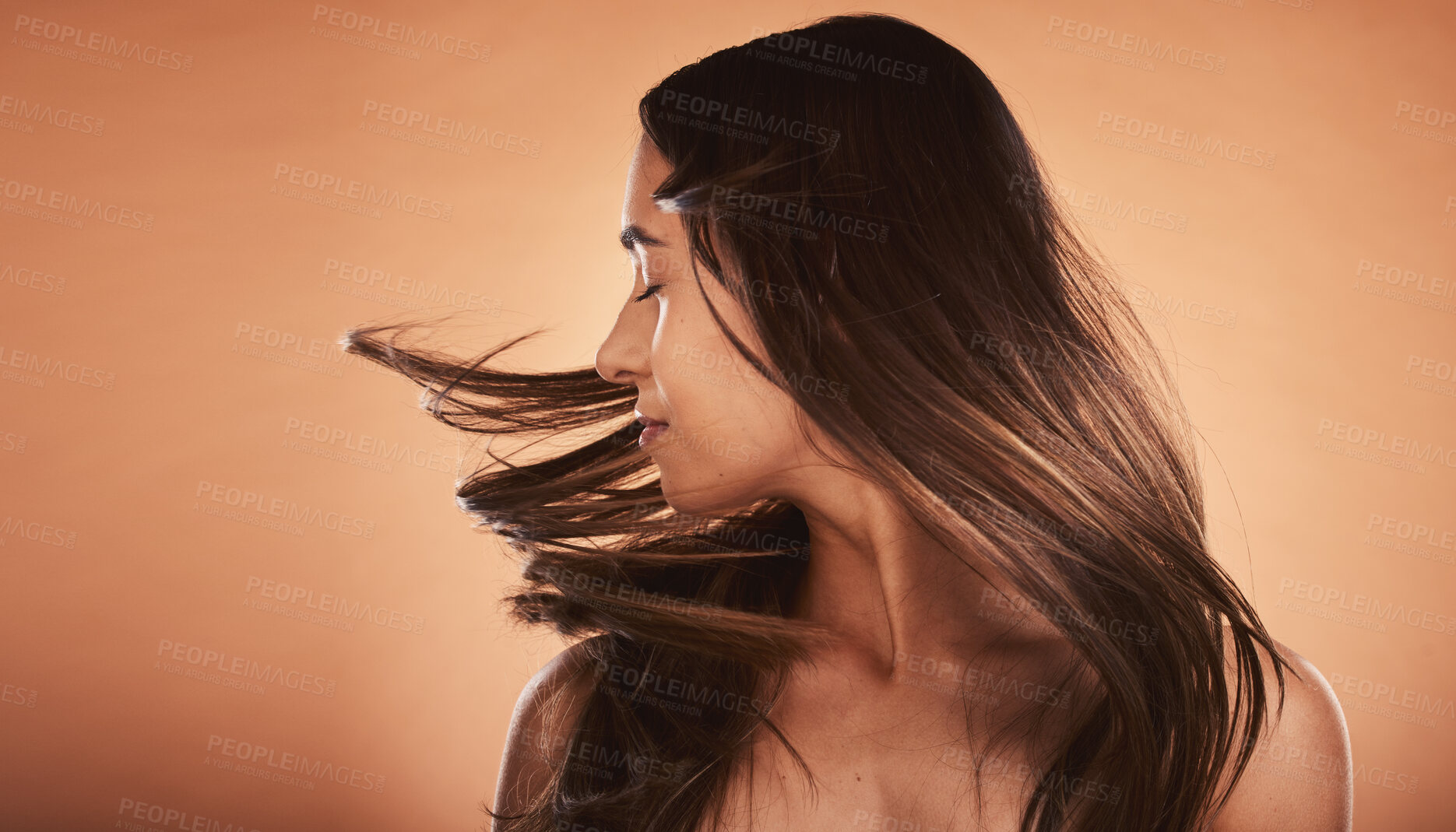 Buy stock photo Hair care, beauty and woman with care for body against a brown mockup studio background. Cosmetic, content and young girl model flipping her perfect, soft and healthy hair with mock up space