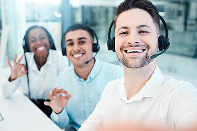 Buy stock photo Selfie, call center and employees with smile, emoji hand and teamwork in telemarketing. Crm, ecommerce and portrait of customer service team with photo, sign for success and working in collaboration