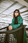 Shopping cart, sunglasses and stylish woman with fashion at a supermarket in the city of Tokyo. Urban, young and portrait of a fashion model shopping with designer, trendy and lifestyle clothes