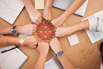 Buy stock photo Hands, collaboration and gear with a business team working together at a table in the office from above. Teamwork, planning and synergy with a man and woman employee group in a huddle or circle