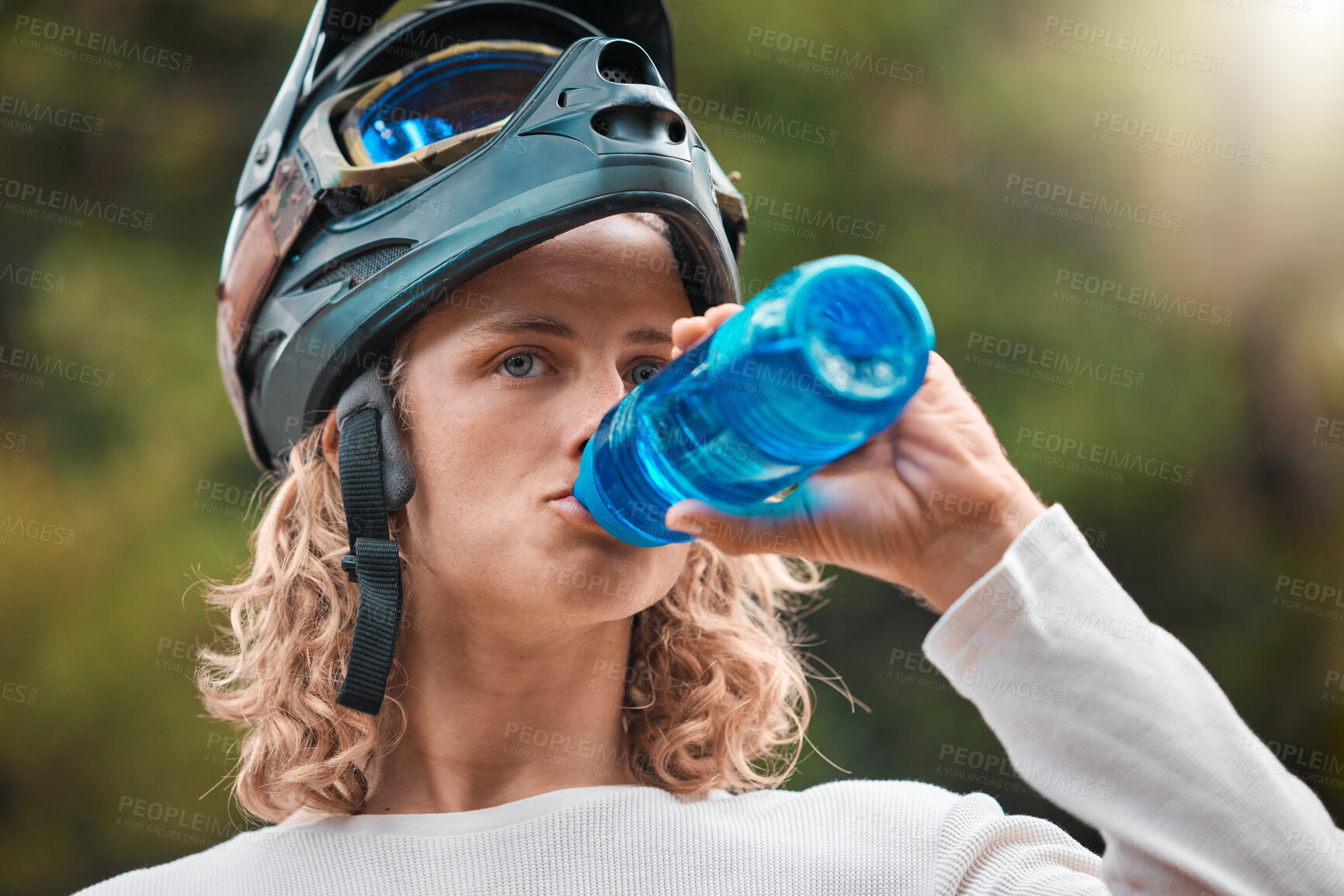 Buy stock photo Water bottle, drink and man in mountain bike travel, journey or adventure in nature forest for wellness, fitness or sports. Cycling sports person in safety helmet gear drinking water in the woods