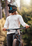 Biker, mountain bike and competition outdoor for extreme sports, helmet and have fun in summer, sunlight and in nature. Young man, athlete and bicycle with head gear for safety, protection and glare
