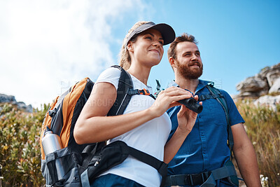 Buy stock photo Hiking, binoculars and love with a couple on a mountain, enjoying a view while walking out in nature together. Summer, adventure and backpack with a man and woman sightseeing outdoor in the mountains