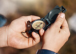 Hands, compass and travel for direction, map or location in adventure, hike or navigation in the outdoors. Hand of traveler holding tracker for scope, tourism or hiking in exploration for journey