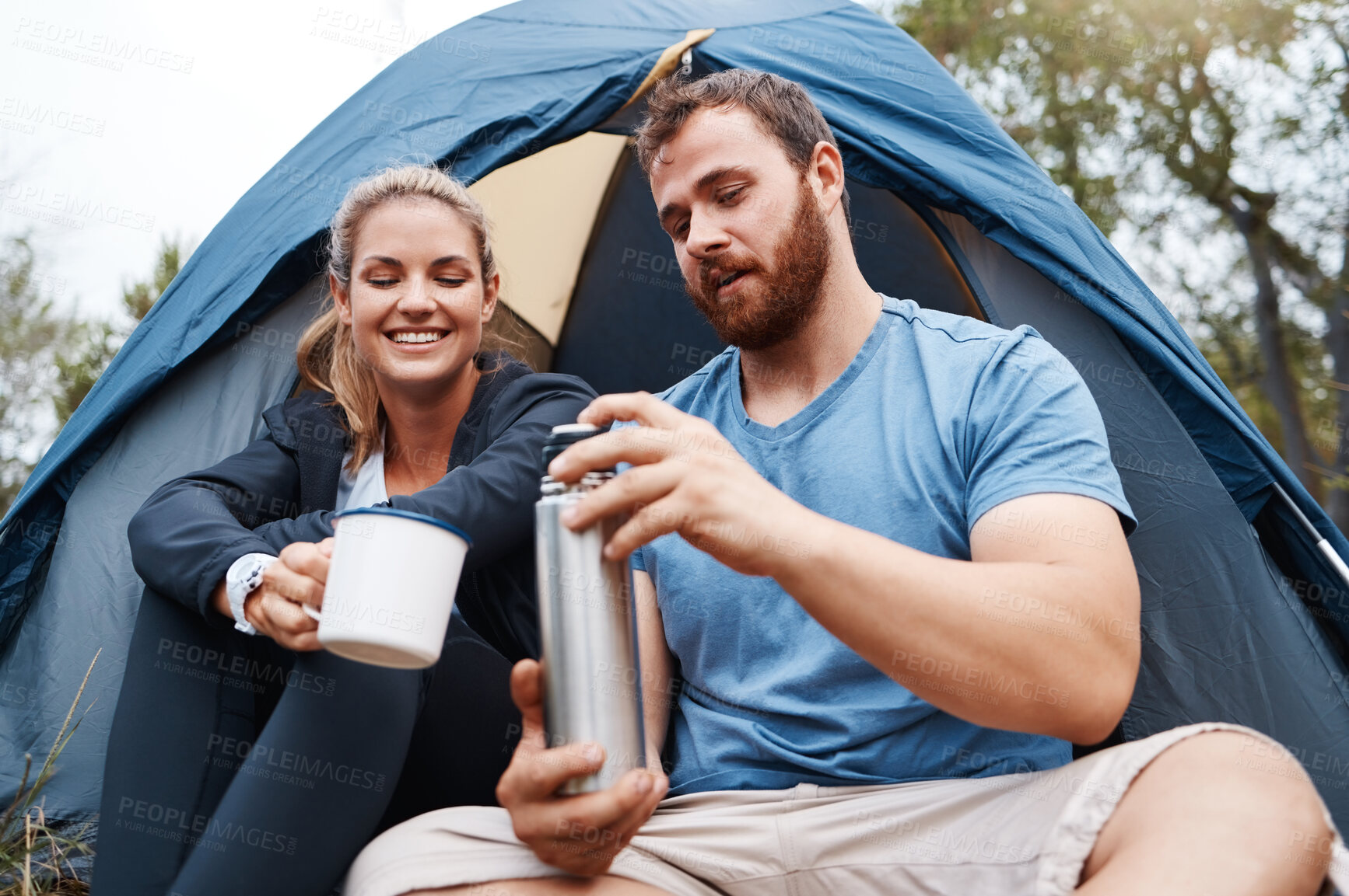 Buy stock photo Camping, tent and couple with coffee in morning, enjoying being outdoors, nature and vacation. Freedom, travel and man with flask pouring hot beverage for woman on camp holiday, weekend and adventure