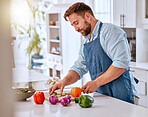 Man, chef and cooking, cut vegetable in kitchen and healthy with diet, nutrition and vitamins preparing dinner or lunch meal. Food at home with apron and organic, fresh pepper and onion.
