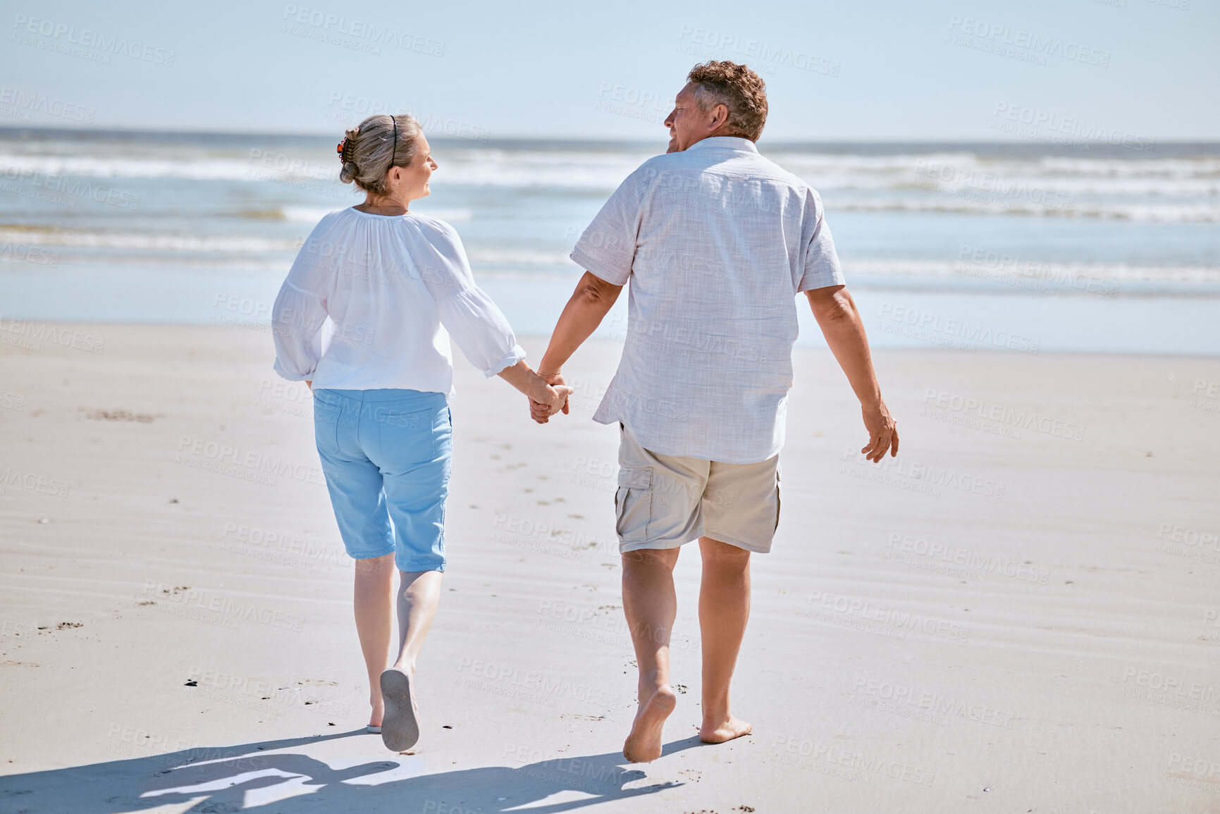 Buy stock photo Senior couple, beach and retirement vacation walking, talking and happy about fitness, summer and travel together. Man and woman show happiness, love and marriage support on nature holiday by water