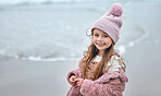 Happy girl child on beach, portrait on winter holiday with pink beanie and kid's smile on the Dublin seaside. Outdoor freedom on ocean break, cute toddler relaxing by the water and coastal peace