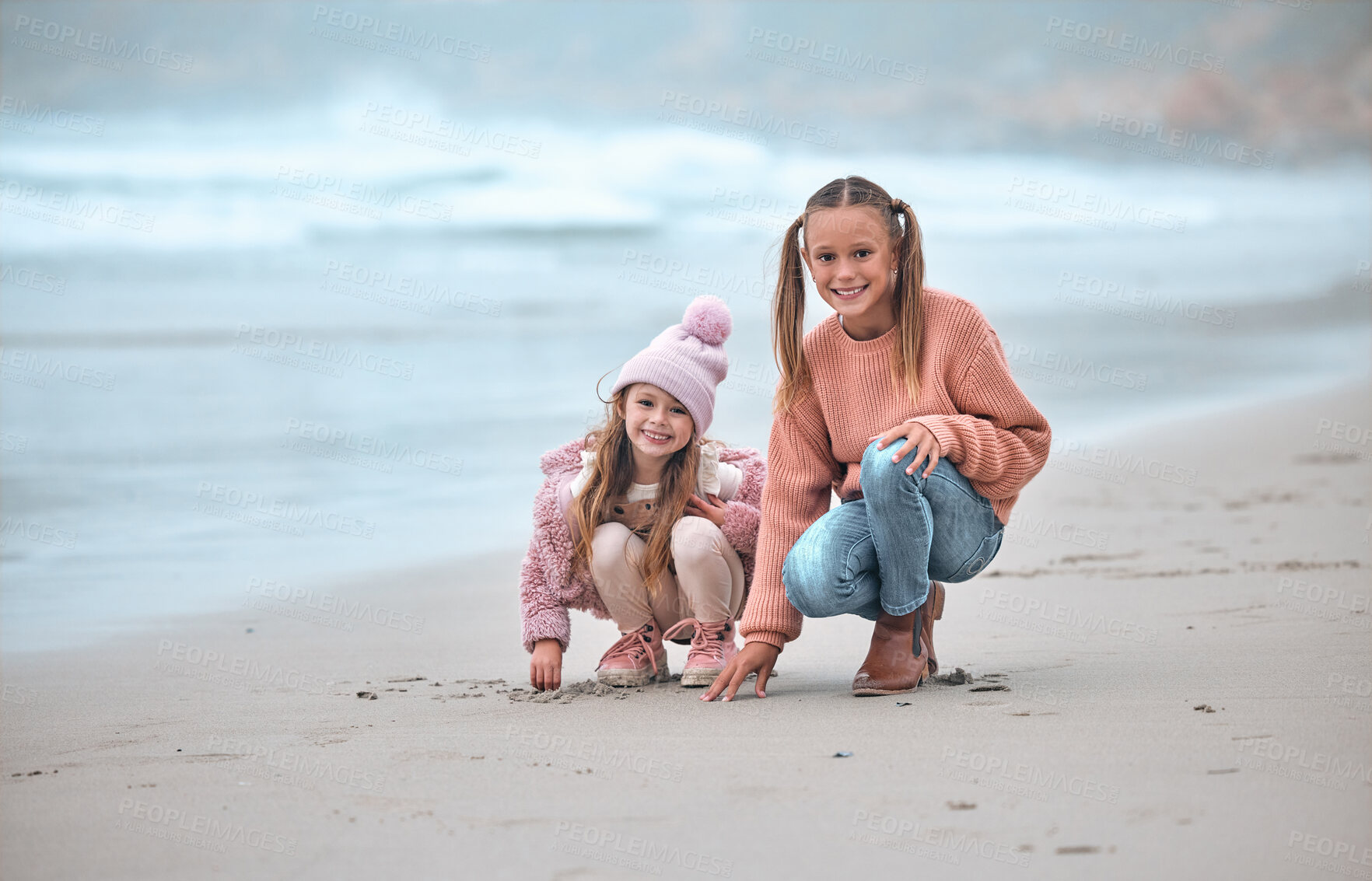 Buy stock photo Sisters, beach and happy with smile, on sand and have fun together being playful, joy and cheerful for holidays. Portrait, siblings or girls at ocean for bonding, loving or seaside vacation for break