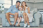 Happy, smile and portrait of a family on a sofa to relax and bond together in the living room of their home. Happiness, mother and father sitting with their girl child on couch in their modern house.