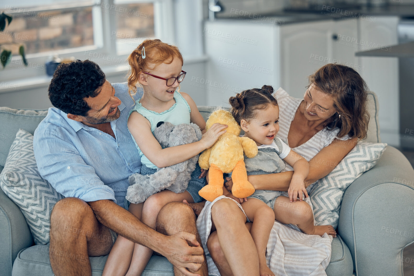 Buy stock photo Family, happiness and love on home sofa with children holding stuffed animal toys while bonding with mom and dad parents. Woman, man and girl kids together for care, development and quality time