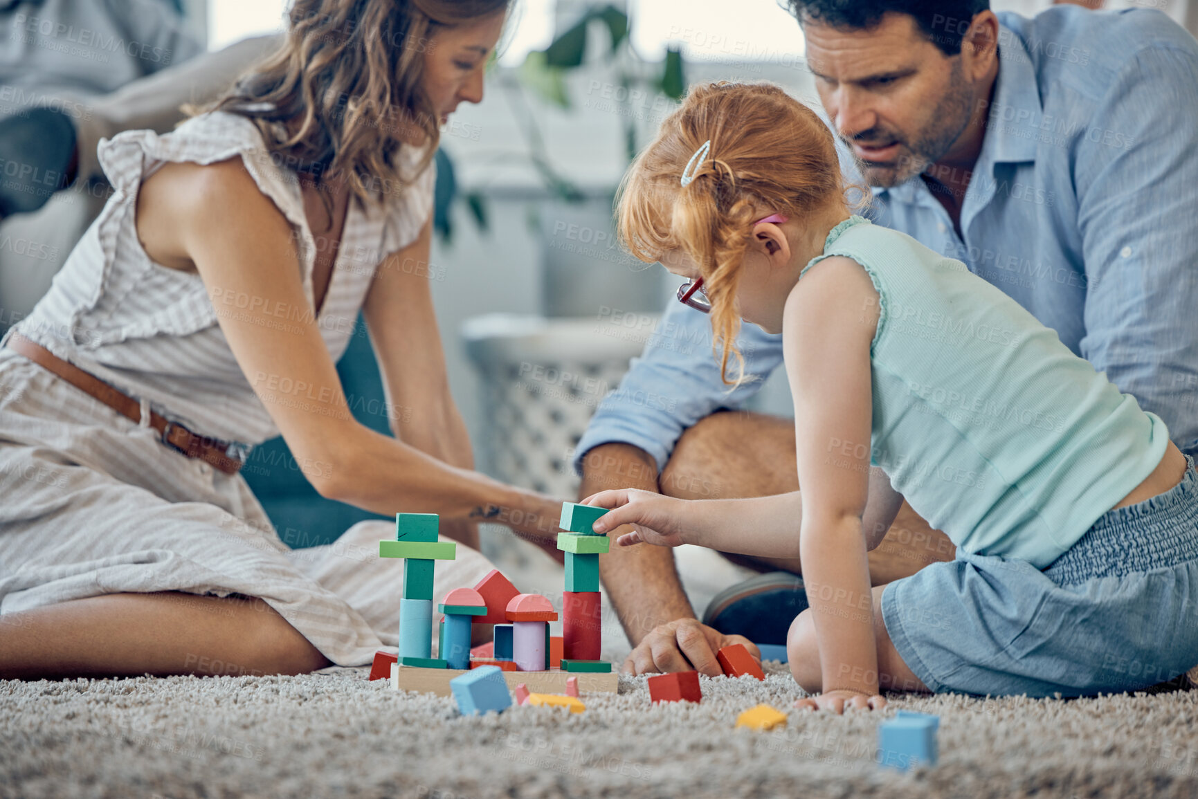 Buy stock photo Family, building blocks and girl playing or learning in home, having fun and bonding with parents. Development, love and support of caring father and mother with kid enjoying toys together in house.
