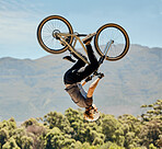 Mountain bike, man and upside down air jump, action and bicycle stunt, challenge and adventure, freedom or dynamic risk in sky. Biker athlete, sports adrenaline and energy in outdoor competition show