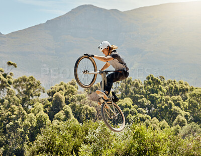 Buy stock photo Sport, action and biker doing jump in air with mountain bike for extreme sports, adrenaline and hobby. Fitness, adventure and woman on bike doing trick shot, jumping and stunt on bicycle in nature