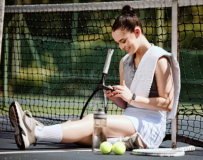 Buy stock photo Relax, fit and phone with woman tennis player browsing, social media or web outdoor on the court. A happy young female athlete or sportswoman posting her sport training online or on the internet