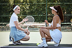 Tennis player women, sitting on court talking and rest together at training, game or contest with smile. Happy athlete conversation, tennis racket and ball for fitness, health or exercise in sports