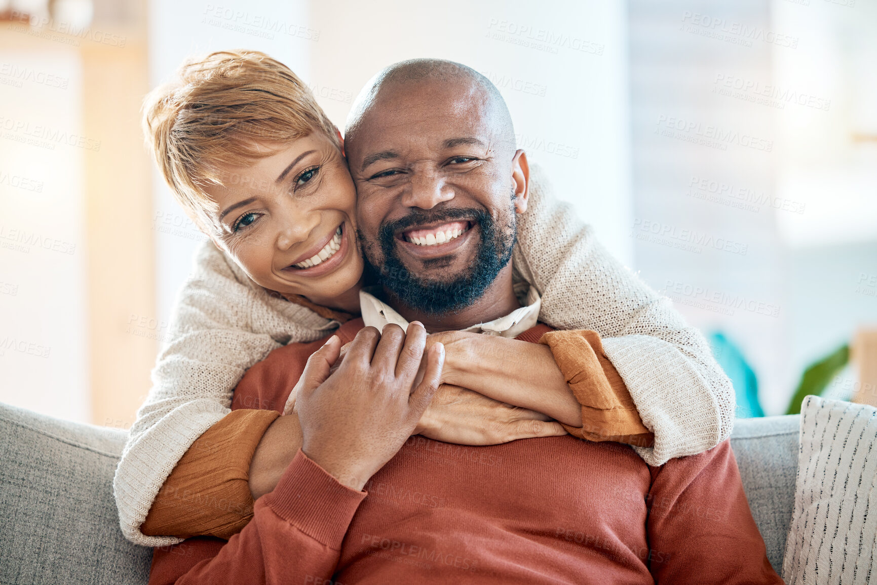 Buy stock photo Marriage, couple and hug portrait at sofa with loyalty, happiness and care in home lounge. Love, black woman and black man relax in house living room together with happy smile and embrace.

