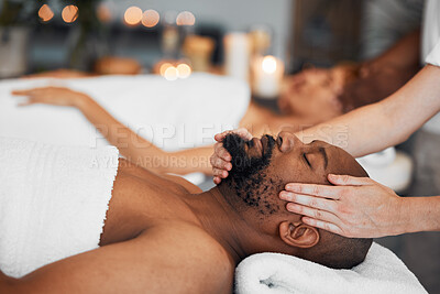 Buy stock photo Spa, couple and massage for health and wellness at luxury resort for peace, calm and quiet time with hands of therapist in a beauty salon. Black man lying on bed for body, mind and head care at hotel