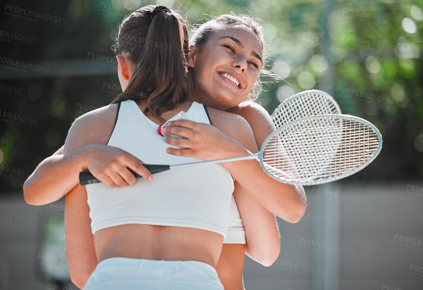 Buy stock photo Badminton, happy and sports friends hug together for bond, love and care with smile on game break. Exercise, workout and happiness in women friendship with embrace on outdoor summer court.

