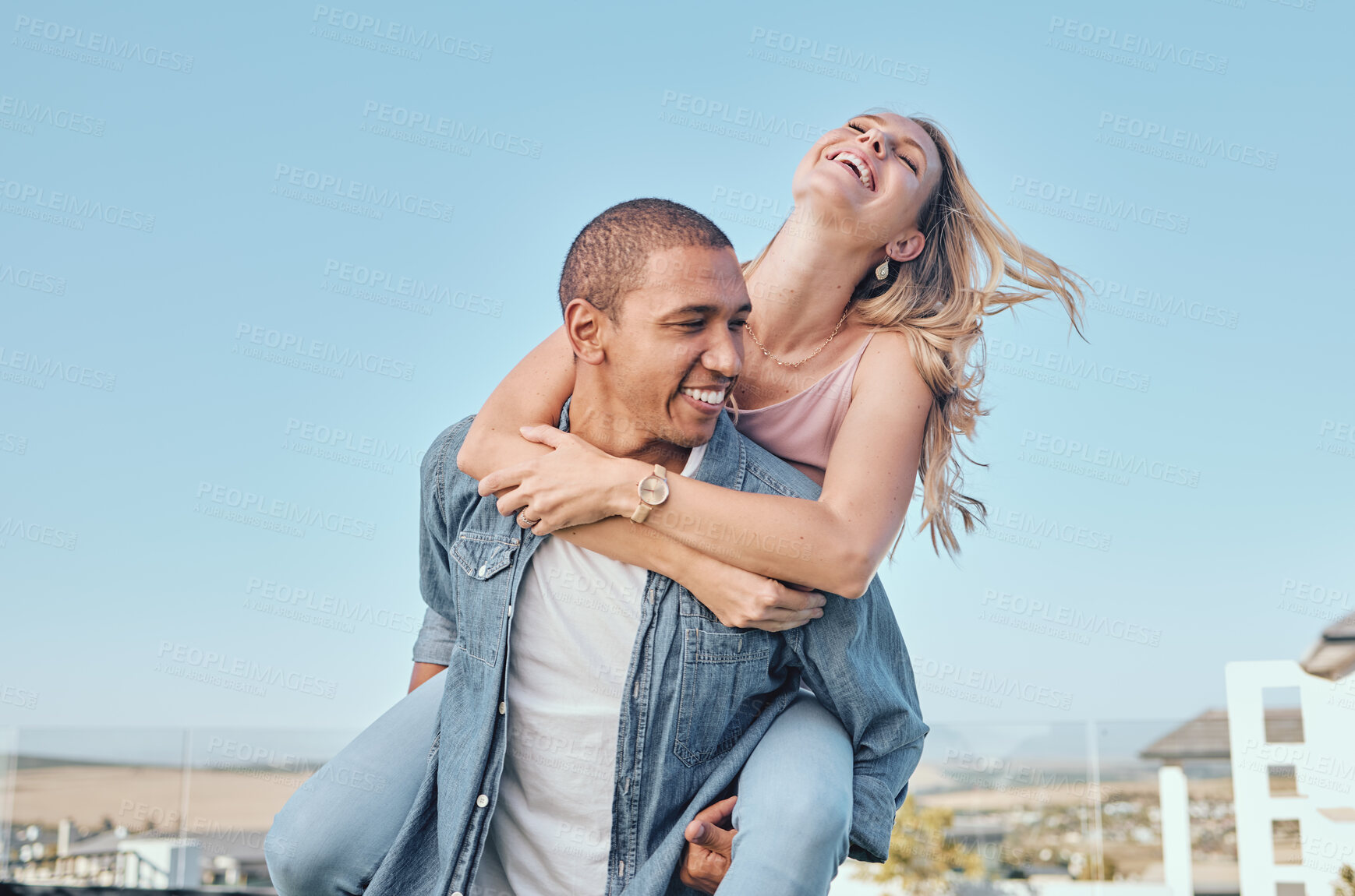 Buy stock photo Interracial, couple and piggy back with outdoor fun of a happy girlfriend and boyfriend feeling love. Happiness of a woman and man together for anniversary or engagement announcement with a smile