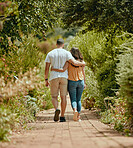Hug, walk and couple on a path in nature for peace, relax and bonding together in summer. Back of a man and woman with affection, hugging and walking with love in a park or garden during spring