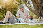 Love, happy and elderly couple relax, bond and rest in a park, having fun on a picnic date and calm. Family, retirement and senior man and woman sharing romance, happy and smile against forest tree 